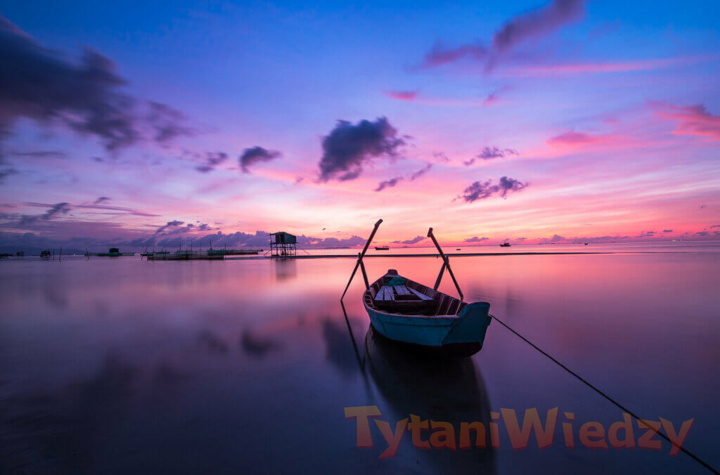 Zachód słońca nad wodą z łódką